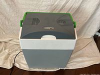 Full view of Mobicool cooler/warmer with green handles and grey body showing overall shape and design.