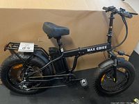 Side view of black folding electric bike with MAX EBIKE branding, fat tires, rear battery pack and cargo rack