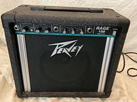 Front view of Peavey Rage 158 guitar amplifier showing front panel with gain, equalization, input, output, and headphone controls along with Peavey logo speaker grill.