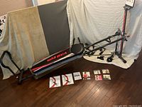 Full view of Total Gym Titanium machine with bench, frame and visible attachments on floor