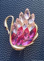 Front view of a crystal swan sun catcher with pink and clear glass crystals on a gold frame.