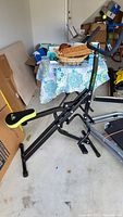 Ab Booster Plus exercise bike showing black metal frame with padded green and black seat, and angled frame support.
