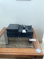 Sony STR-AV570 Audio/Video Control Center and remote with cables on a glass table.