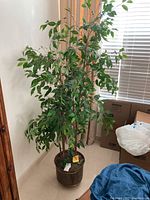 Full view of the large faux tree with green leaves and multiple trunks inside the metal planter pot.