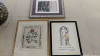 Three framed prints arranged showing various floral and an illustrated quote print