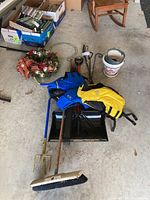 Overview of all items in lot including yard tools, safety vests, planters, and holiday wreath.