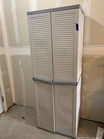 Front view of the tall beige and gray Black & Decker cabinet with closed double doors.