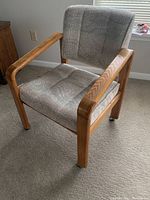Danish Modern chair angled view showing wooden arms, legs, and textured gray fabric upholstery on seat and backrest.