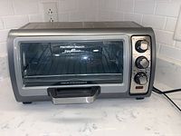 Full view of Hamilton Beach Easy Reach Toaster Oven on countertop showing front door with handle and control knobs on right side.