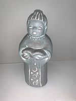Front view of signed cement angel sculpture showing detailed face, hair design, necklace and dress decoration.