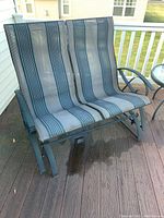 Front and side views of two-seat outdoor glider rocker with striped fabric upholstery on a wood deck