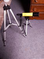 Photo showing the yellow National Geographic telescope mounted on a small tripod stand alongside a larger extendable tripod stand.