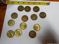Top view of all 14 Canadian provincial coins arranged in a flat layout with measuring tape for scale.