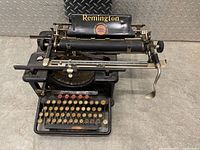 Front angle view of black Remington typewriter showing full keyboard and typebars.