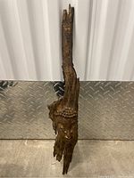 Full front view of the carved Buddha face integrated into elongated driftwood piece