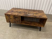 Front view of rectangular coffee table showing wood-grain finish, open and closed storage compartments