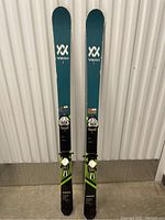 Full view of the pair of Völkl Transfer 89 skis standing upright showing branding and design