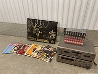 Overview of the Yamaha deck, magazines, VHS tapes, and framed photo arranged on floor.