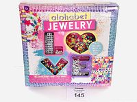Front of box showing 'alphabet JEWELRY' title and display of beads in heart and letter shapes with a colorful background.