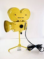 Front and side angle view of yellow Hollywood Studio lamp shaped like a vintage film camera with attached power cord and tripod stand.