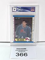 Front view of Joe Sakic rookie card in protective slab graded 9 with player in Quebec Nordiques uniform.