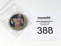 Kobe Bryant commemorative coin in protective plastic pouch beside an auction lot number card.