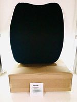Front view of the Mkicesky lumbar support pillow on top of its original cardboard box with instruction manual visible at the front.
