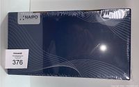 Sealed dark blue rectangular box of the Naipo neck and shoulder massager with shiatsu kneading and heat function. Box features white Naipo logo and minimalistic wavy line design.