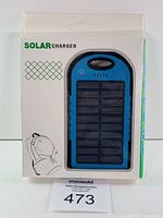 Front packaging of the solar charger showing blue and black solar charger device with solar panel front, hanging tab and branding text.