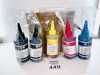 Five ink refill bottles in sealed plastic including two black, one yellow, one magenta, and one cyan.
