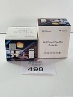 Two boxed Wi-Fi Smart Plug Mini 2 packs showing front with living room setting and Alexa compatibility icons