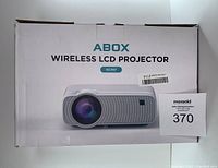 Photo of the ABOX wireless LCD projector box showing model GC357 and an image of the projector.