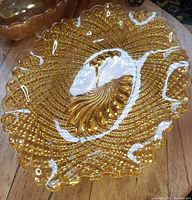 Front view of amber carnival glass dish showing textured detail and ruffled edges.