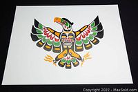 Photo showing a First Nations print of a bird with outstretched wings in typical indigenous art style and colors.