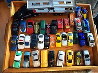 Overview of 32 assorted toy cars laid out in a tray, various colors and styles.