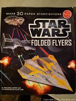 Front cover of the Star Wars Folded Flyers Klutz book showing three Star Wars starfighter paper models in action.