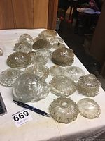 Various glass bobeches arranged on a surface showing different sizes and designs.