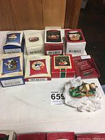 Photo showing ten Hallmark Keepsake cat-themed Christmas ornaments in original boxes with one ornament unwrapped and displayed. Boxes are various colors and sizes showing original packaging.