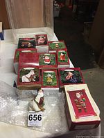 Full lot showing 10 boxed Hallmark Keepsake Santa ornaments with one unboxed Santa ornament in front, sitting beside a polar bear figure.
