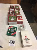 Photo showing eight boxed Hallmark Keepsake snowman ornaments plus one star-shaped ornament box and one snowman ornament removed from box placed on a white surface.