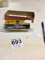 Yellow jail box car body and unassembled parts packed inside a brown box labeled 'Jail Box Car'.