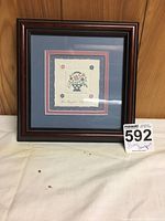 Full front view of the framed embossed artwork 'Love's Bouquet' showing the double matting and wood frame.