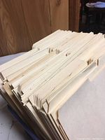 Large stacks of manila folders laid flat, showing unbent crease and neat edges, off-white tan color.