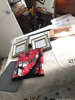 Photo showing four small photo frames in white and metallic finishes along with two tablet covers, one floral and one solid gray.