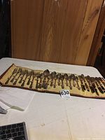 Full view of the flatware set in the fabric roll-up case, showing all pieces laid out