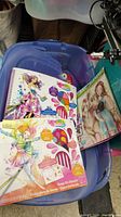 Blue plastic bin holding three new children's crafts art supplies including two Splash watercolor paint sets and one art sketchbook