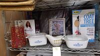 Photo of vintage Corning Ware casserole dishes and matching creamer on metal shelf, showing Blue Cornflower and Spice of Life patterns.