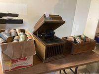 Overall view of Edison phonograph with two boxes of cylinder records on wooden table