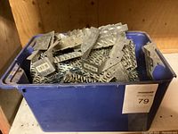 Blue plastic tote filled with galvanized steel 2x6 joist hangers and gang nails for framing construction.