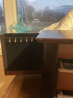 Left side swing compartment with 7 hooks for necklaces or bracelets inside black felt lining.